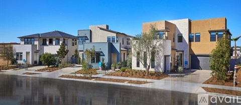A row of modern houses with a body of water in front.