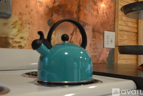 A blue tea kettle sits on a white stove.