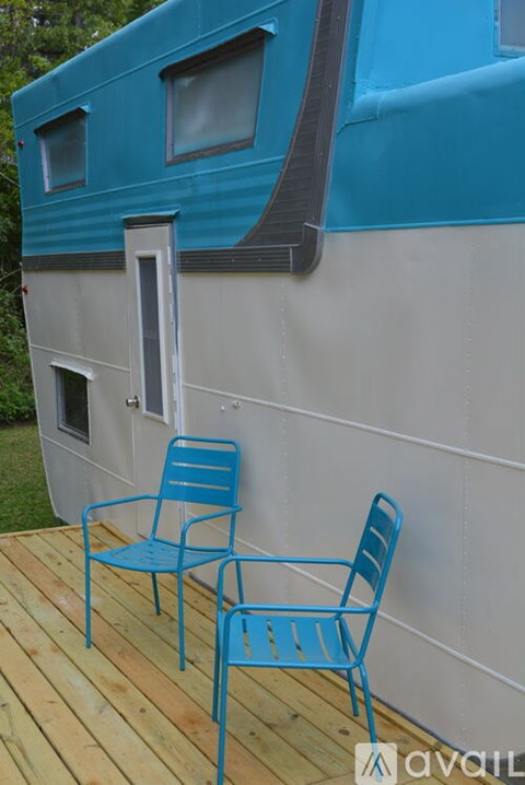 Two blue chairs are on a wooden deck.