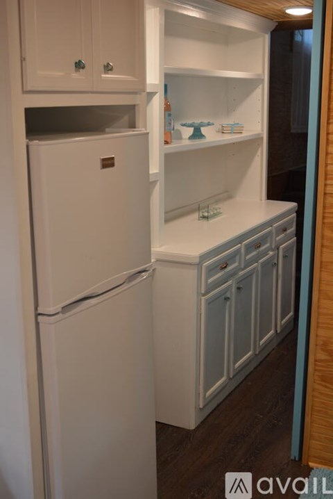 A white refrigerator with a freezer drawer and a white counter top with a few items on it.