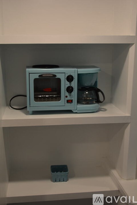 A blue toy oven and coffee maker on a shelf.