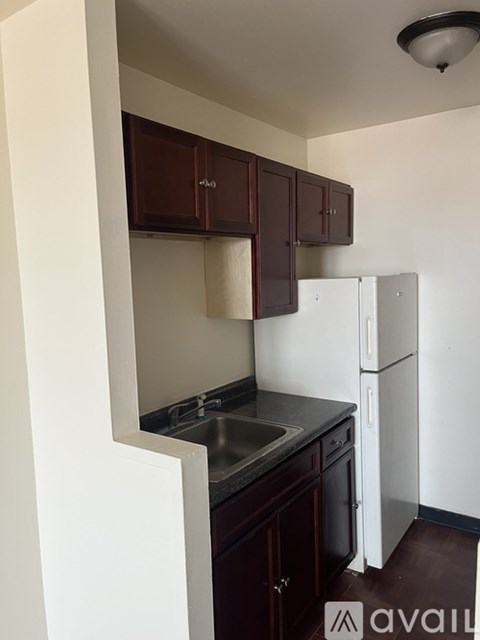 A kitchen with brown cabinets and a white fridge.