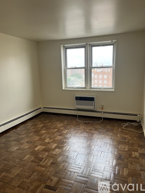 A room with a window and a wooden floor.
