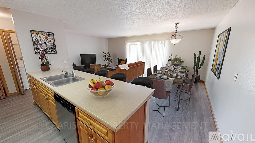 A kitchen with wooden cabinets and a countertop with a bowl of fruit on it.