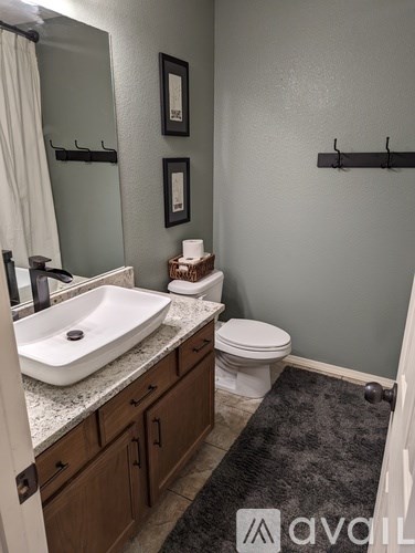 A bathroom with a sink, toilet and a mirror.