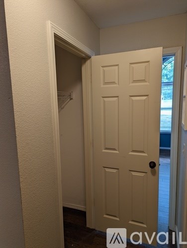 A white door with a black handle is open.