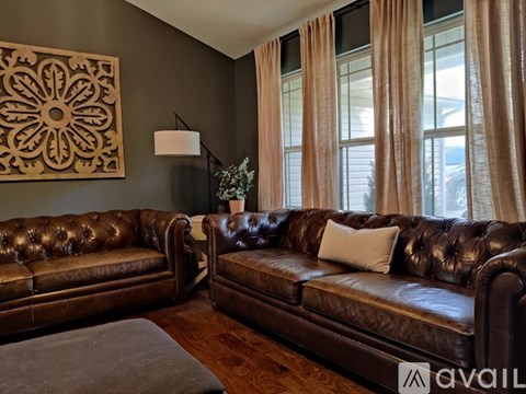 Two brown leather couches in a living room.