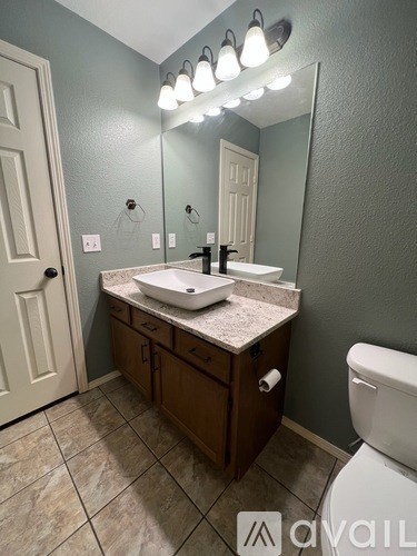 A bathroom with a sink, mirror, and toilet.