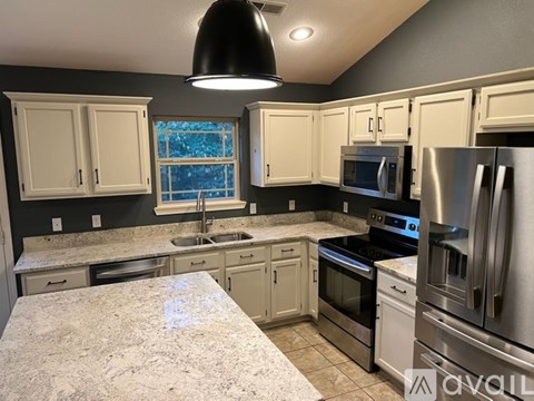 A kitchen with a granite countertop and stainless steel appliances.