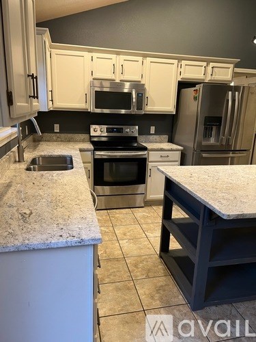 A kitchen with granite countertops and stainless steel appliances.