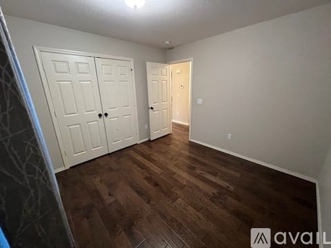 A room with two doors and a wooden floor.