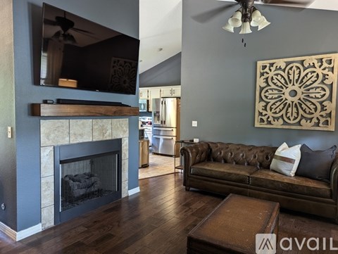 A living room with a fireplace and a brown couch.