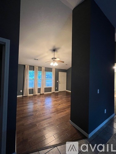 A room with wooden floors and a ceiling fan.