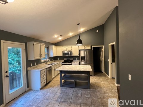 A kitchen with a marble countertop and a large island.