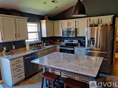 A kitchen with a granite countertop and stainless steel appliances.
