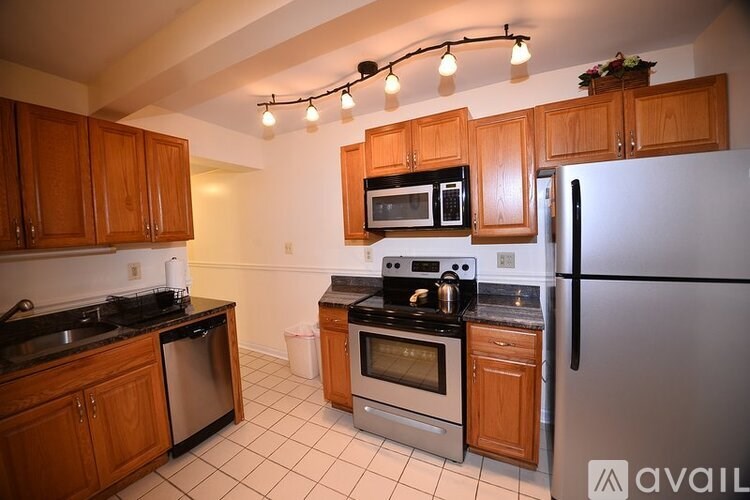 A kitchen with wooden cabinets and a black counter top.