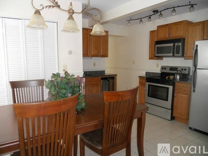 A kitchen with a table and chairs.