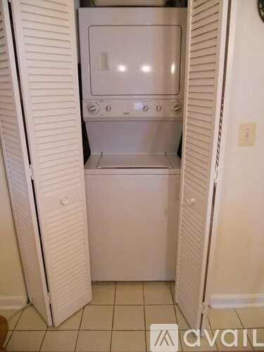 A white oven is built into a white cabinet.