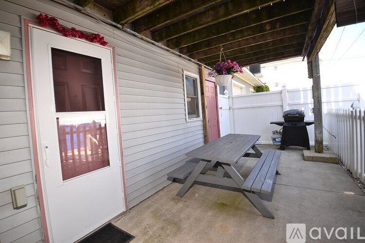 A patio with a table and bench outside a house.