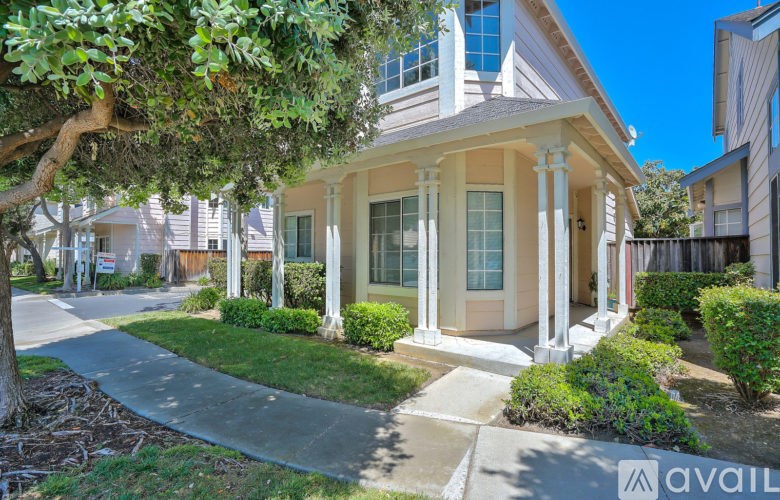 A house with a front porch and a tree in front of it.