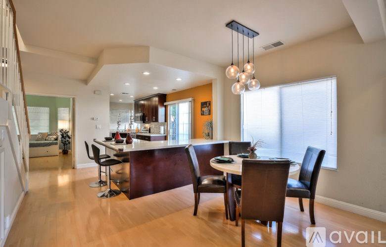 A modern dining room with a wooden table and chairs.
