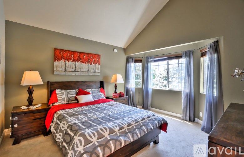 A bedroom with a large bed and a painting on the wall.