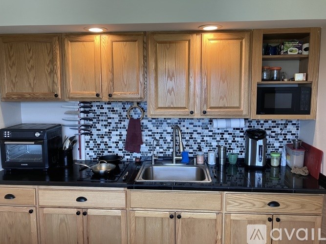 A kitchen with wooden cabinets and a black countertop.