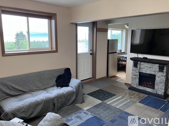 A living room with a grey couch and a fireplace.