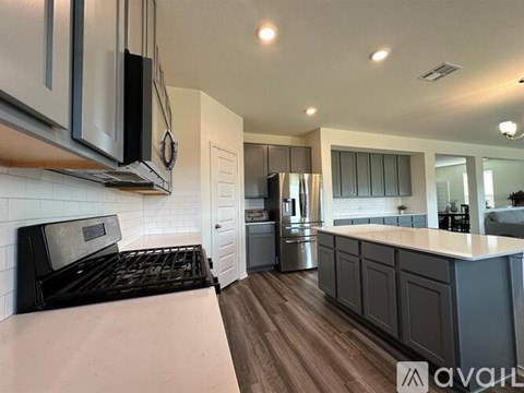 A kitchen with a black stove top oven and a white tiled backsplash.