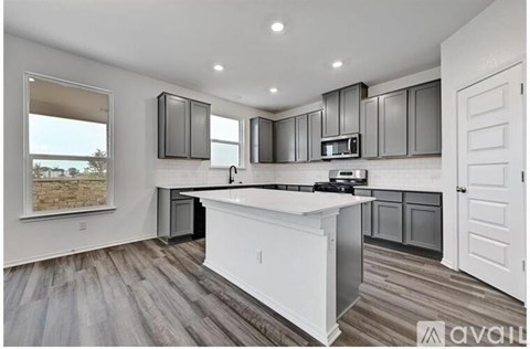 A modern kitchen with a white island and dark wood cabinets.