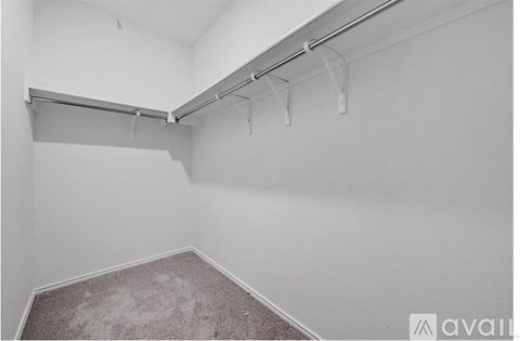A white room with a grey carpet and a white wall.