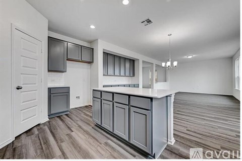 A kitchen with a white door and grey cabinets.