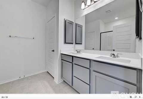 A white bathroom with a sink and mirror.