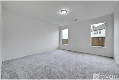 A spacious room with a carpeted floor and a window.