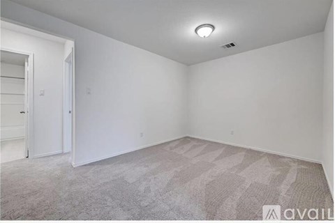 A room with a carpeted floor and a door on the left side.