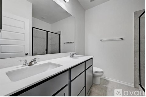 A bathroom with a white sink and toilet.