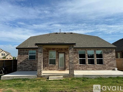 A house with a brown roof and brick walls is for sale.