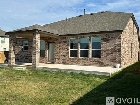 A house with a brown brick exterior and a grey roof is for sale.