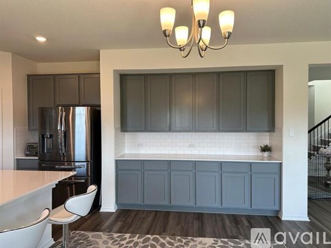 A kitchen with a white countertop and a stainless steel refrigerator.