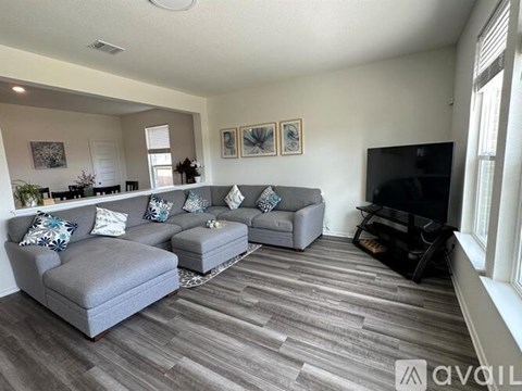 A living room with grey couches and a black television.