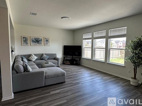 A living room with a grey couch and a television.