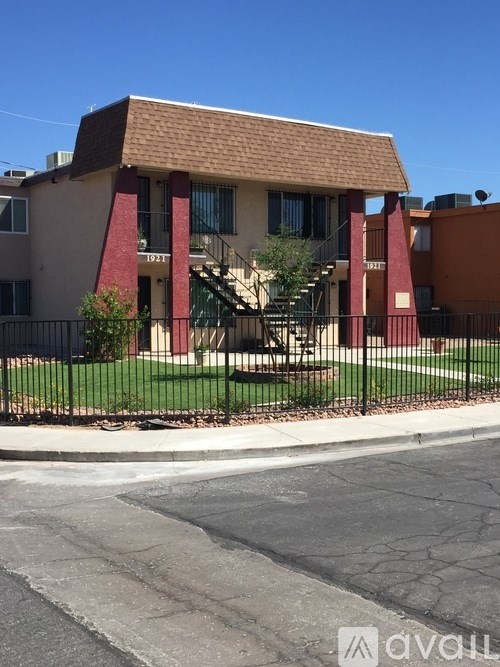 A building with a red roof and a black fence in front of it.
