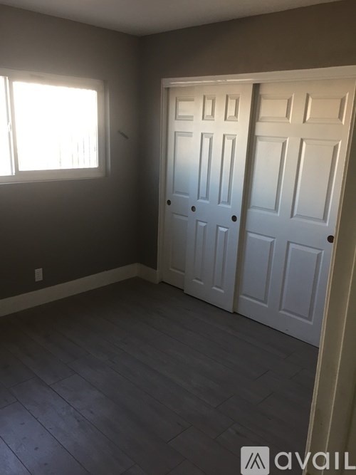 A room with two white doors and a window.