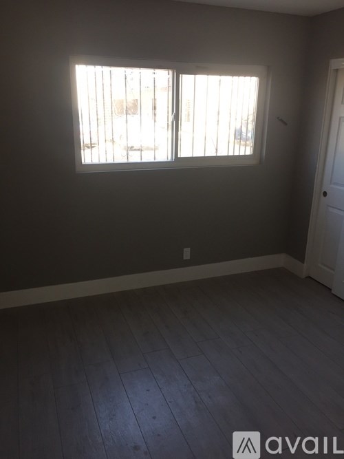 A room with a window and wooden flooring.