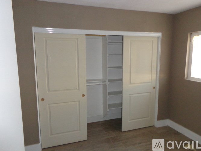 A room with two white doors, one of which is open.