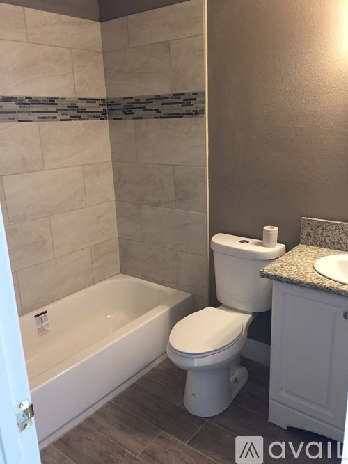 A white toilet sits next to a bathtub in a bathroom.