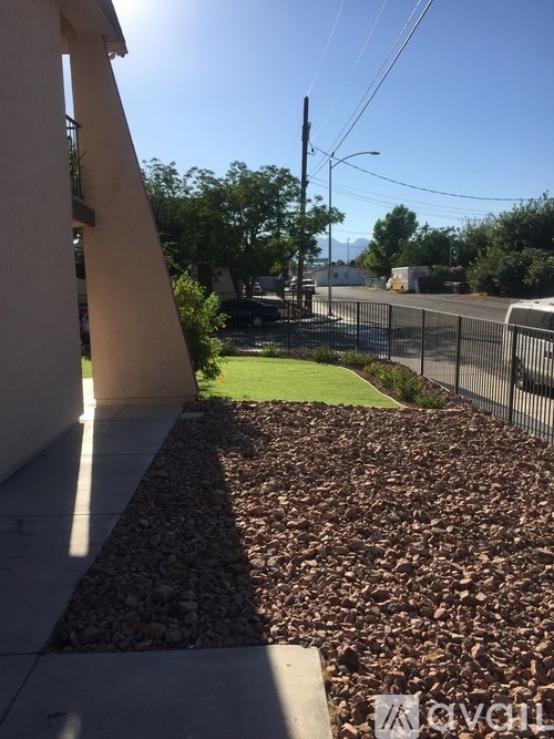 A sunny day with a clear blue sky and a fence in the background.