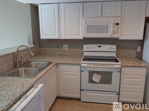 A kitchen with white cabinets and a granite countertop.