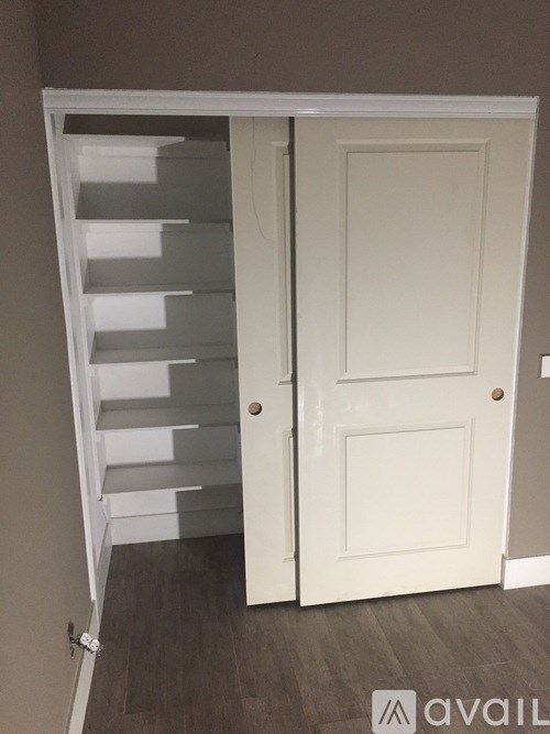 A white door with a white shutter on the side.