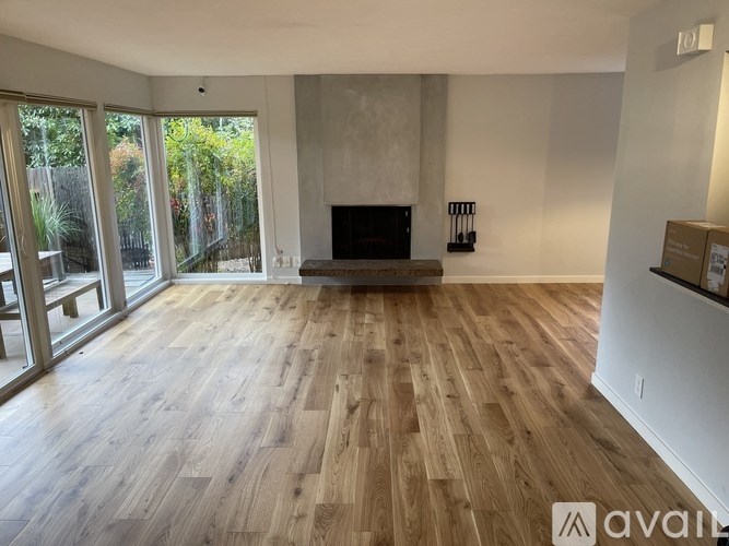 A living room with a fireplace and wooden flooring.